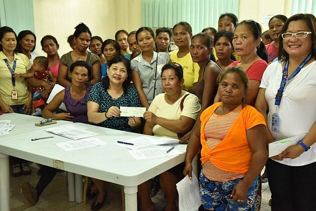 DSWD Regional Director Ma. Evelyn Macapobre (seated, center) hands over the check for P460,000 to the 23 Modified Conditional Cash Transfer program beneficiaries of Barangay Umapad. (CONTRIBUTED) 