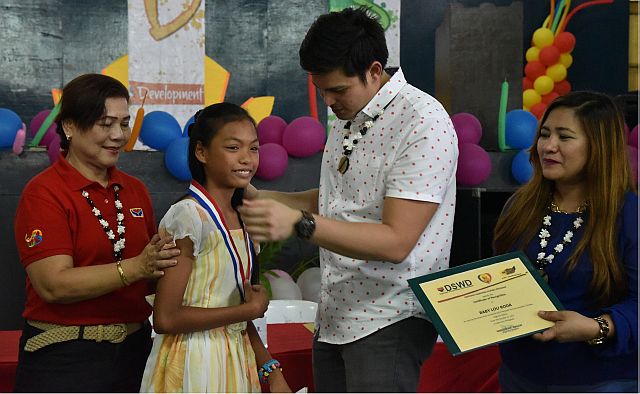 Former NYC commissioner Jose Sixto “Dingdong” Dantes III awards Baby Lou Roda, the grand prize winner of the 2015 regional search for Pantawid Pamilya Exemplary Children during the launching of Youth Development Session October last year in Abellana National School. (CONTRIBUTED)