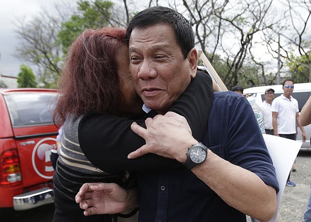 Presumptive Presidential Rodrigo Duterte is hugged by a supporter before attending a forum at the University of the Philippines in Quezon City in this Feb. 18 file photo. (AP)