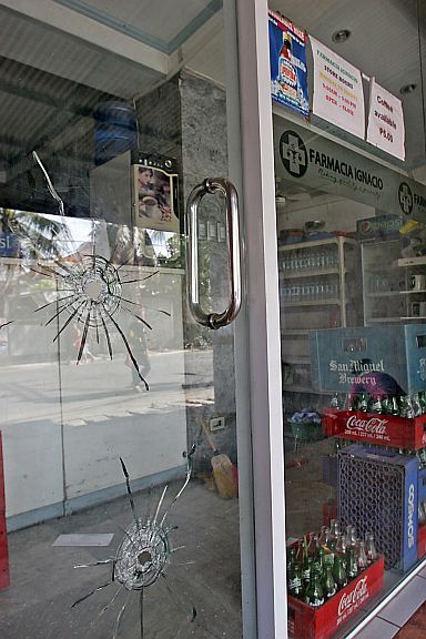 CANDIDATES PHARMACY STRAFED/MAY 2, 2016: Large ballets holes on the glass door of Pharmacia Ignacia on T. Padilla Ext. barangay Tejero owned by Inayawan barangay Captain Lotlot Ignacia who is running as councilor for Team Rama after it was strafed by unidenmtified motorcycle gunmen.(CDN PHOTO/JUNJIE MENDOZA)