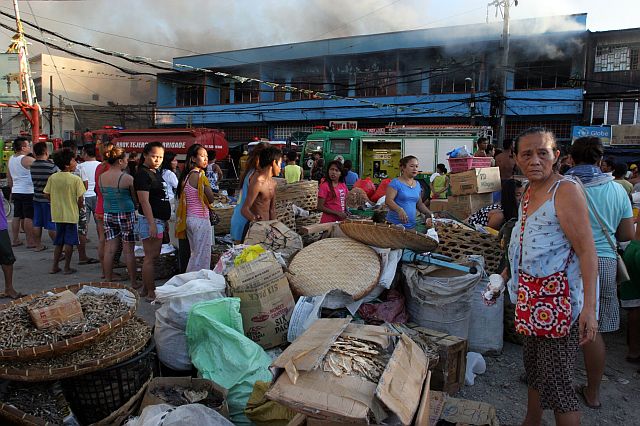 7 DIED IN THE EARLY MORNING FIRE/MAY 7, 2016: Dried fish vendors save their merchandize from their burning store building and houses as Tabuan barangay San Nicolas. More than 70 houses were burn down at the back of the building on barangay Pahina Central which 7 people were killed  including 4 children after they were trapped inside their burning house.(CDN PHOTO/JUNJIE MENDOZA)