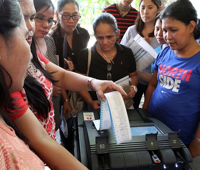 VCM'S FINAL TESTING AND SEALING/MAY 6, 2016: Election watchers is all eyes to the Vote Counting Machine (VCM) during the final testing and sealing in Guadalupe Elementary School.(CDN PHOTO/JUNJIE MENDOZA)