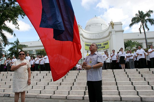 AT THE HELM. Reelected Gov. Hilario Davide III (right) holds steady the Philippine flag while Vice Gov. Agnes Magpale, Capitol officials and employees stand at attention during the flag-raising ceremony. (CDN PHOTO/JUNJIE MENDOZA)