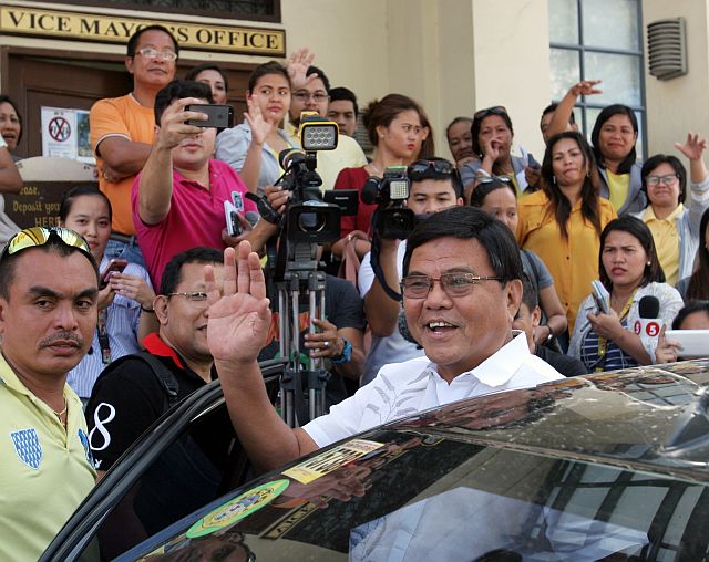 Reelected Cebu City Vice Mayor Edgardo Labella smiles and waves to supporters as he boards a vehicle after learning of his suspension order. (CDN PHOTO/JUNJIE MENDOZA)