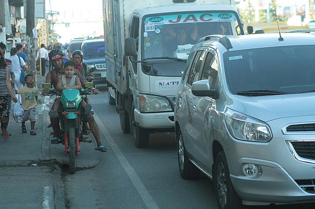 A father and his son on board a motorcycle try to maneuver the heavy traffic along the stretch of M.L. Quezon Street in Lapu-Lapu City after a new route scheme was implemented. (CDN PHOTO/FERDINAND EDRALIN)