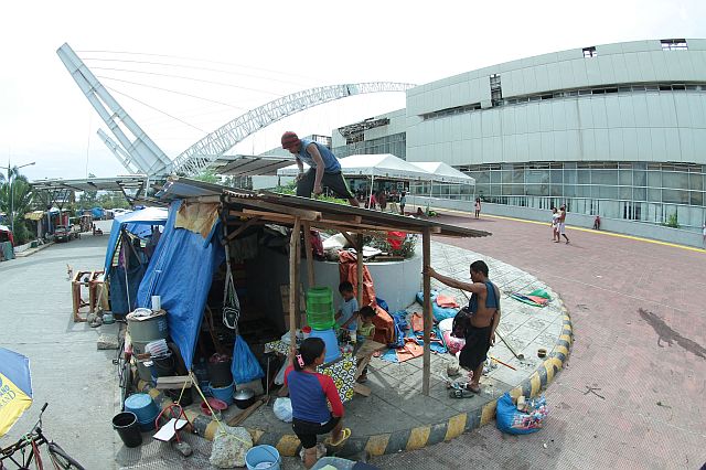 Narciso Hernani fix the roof of their makeshift house inside the CICC compound yesterday after they were drenched by an early morning  heavy rain which signals the coming of the rainy season. (CDN PHOTO/FERDINAND EDRALIN)