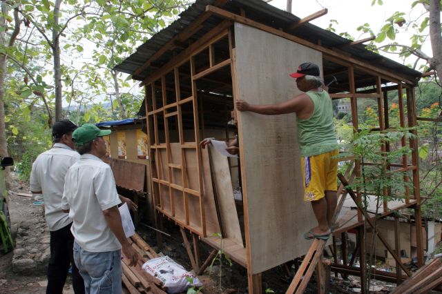 Members of Prevention, Restoration, Order. Beautification and Enhancement (Probe) ask carpenters to stop the construction of houses as they serve notices of demolition to the informal settlers inside the 4.3-hectare Osmeña Shrine in Barangay Kalunasan. (CDN PHOTO/JUNJIE MENDOZA)