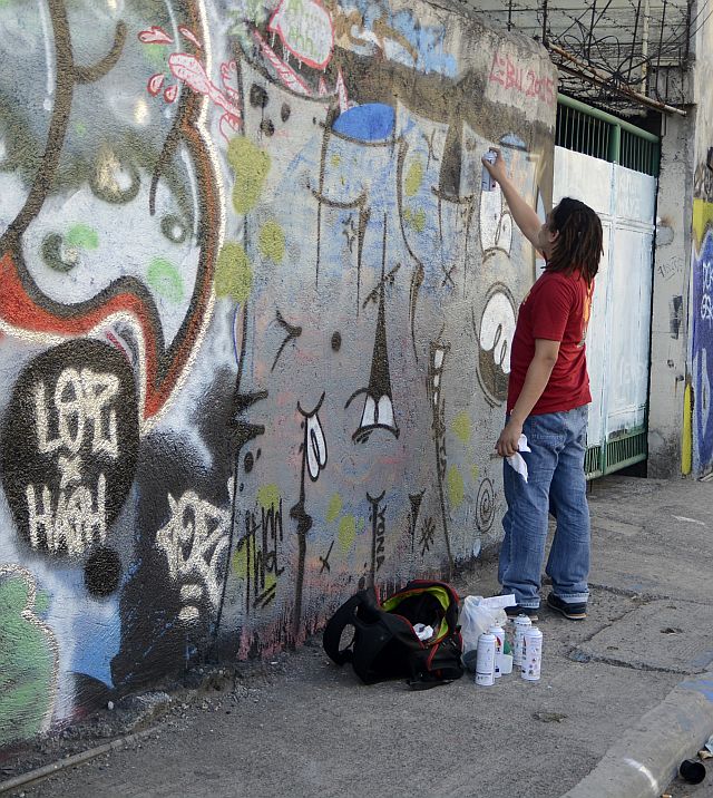 SILOY IS WATCHING/MAY. 01, 2016 An artist named Mano restoring graffiti along Escario street. (CDN PHOTO/CHRISTIAN MANINGO)