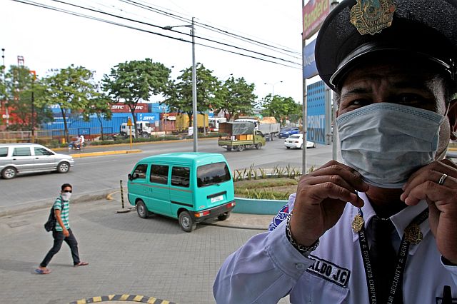 SILOYS WATCH FOUL ODOR IN NORTH RECLA/MAY 24,2016:Cebu Daily News guard cover his nose with a surgical mask while a passerby also covering his nose of a different foul odor from pier area.Attention CPA on these matter.(CDN PHOTO/JUNJIE MENDOZA)