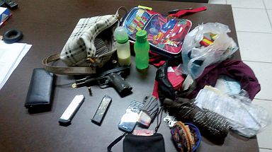A .45 caliber pistol and other items recovered from the site of the shooting incident. Police recovered a backpack and bag that were allegedly taken from the robbery victims. (CDN PHOTO APPLE MAE TA-AS)