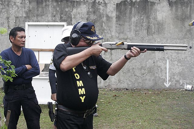 LOCK AND LOAD. Cebu City Mayor Tomas Osmeña shows how to handle and fire a shotgun during a shooting stint with other officials at the Cebu City Police Office in this 2008 file photo. Looking on is SPO1 Adonis Dumpit. (CDN FILE PHOTO)