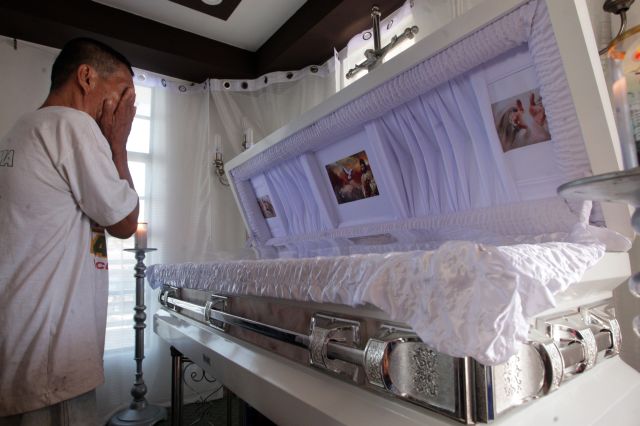 ROBIN HOOD? A Banacon islander weeps upon seeing the body of slain suspected drug lord Rowen “Yawa” Secretaria whose wake is  being held at his rest house on the island, where he was hailed as a generous patron. (CDN PHOTO/TONEE DESPOJO)