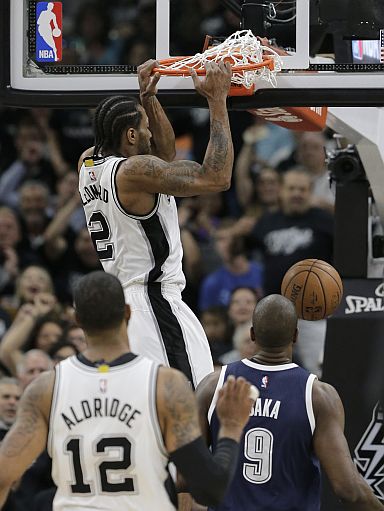 San Antonio Spurs forward Kawhi Leonard (2) scores over Oklahoma City Thunder guard Russell Westbrook (0) during the first half in Game 1 of a second-round NBA basketball playoff series, Saturday, April 30, 2016, in San Antonio. (AP Photo/Eric Gay)