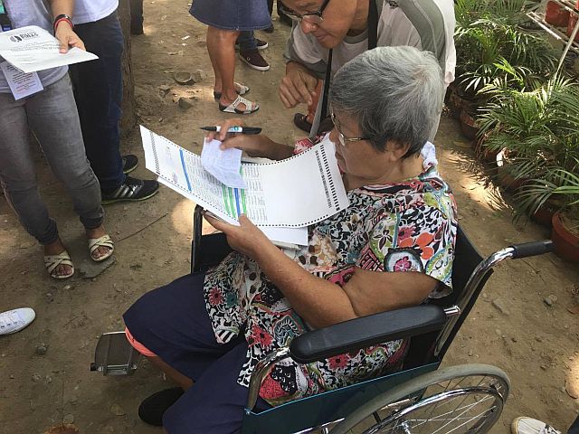 An elderly woman was allowed to cast her vote outside of her assigned precinct in Guadalupe, Cebu City. (CDN PHOTO/JOSE SANTINO S. BUNACHITA)