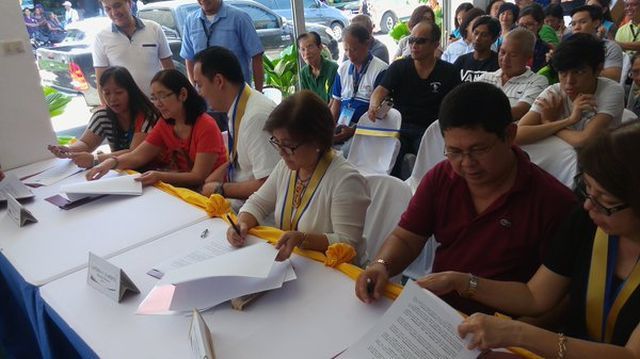 Stakeholders, led by DTI regional director Asteria C. Caberte (3rd from right), sign an agreement for the establishment of a Negosyo Center in Dalaguete. (CDN PHOTO/VICTOR ANTHONY V. SILVA) 