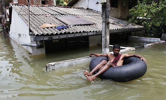 A Sri Lankan man uses an inflatable tube to move through a flood-affected area in Wellampitiya, in the outskirts of Colombo, Sri Lanka. (AP)