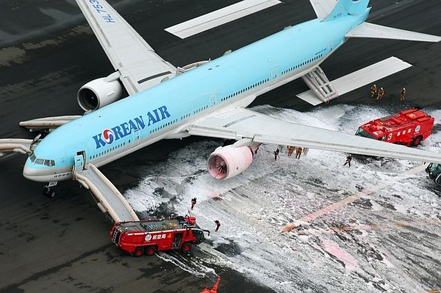Firefighters gather near an engine of a Korean Air jet following an apparent engine fire on the tarmac at Haneda Airport in Tokyo./AP