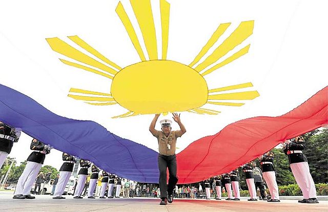 An Army sergeant aligns a giant Philippine flag during rehearsal for the celebration of the 118th anniversary of the proclamation of Philippine independence at the Rizal Monument in Manila. President Aquino leads the commemorative activities on Sunday for the last time. (INQUIRER.NET)