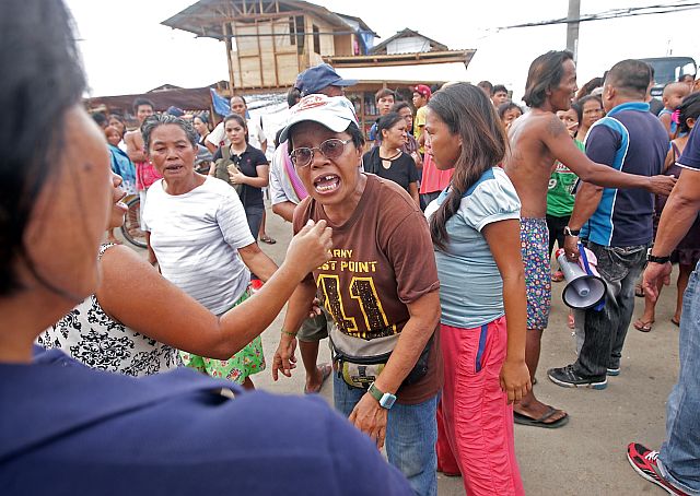Fire victims staying at Barangays Guizo-Mantuyong fire site angrily block Mandaue City workers who arrived at the area to start reblocking operation. (CDN PHOTO/TONEE DESPOJO)