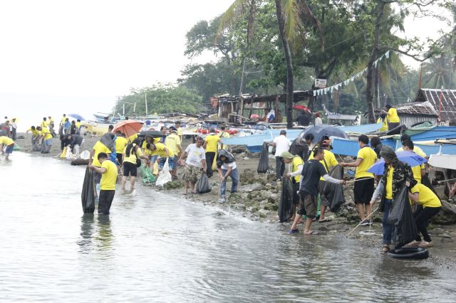 Capitol employees and volunteers retrieve trash from the coastline of Barangay Pooc in Talisay City. (CONTRIBUTED)