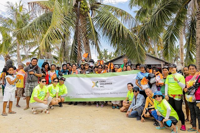 CHI employees headed by CSR and Sustainability Manager Vera Alejandria (first row, rightmost), Fr. Tito Soquiño, OSA, of Sto. Niño de Cebu Augustinian Social Development Foundation (first row, second rightmost), together with the residents of Kinatarcan Island. (CONTRIBUTED) 