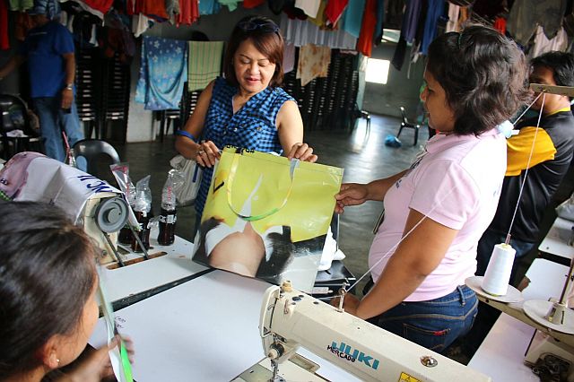 Governor Davide’s wife Jobel inspects the recycled bag manufactured by the CPDRC inmates. (CONTRIBUTED)