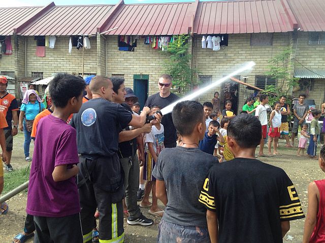 French firefighters teach Barangay Tipolo residents and volunteers how to hold a fire hose. CDN PHOTO/Julit Jainar