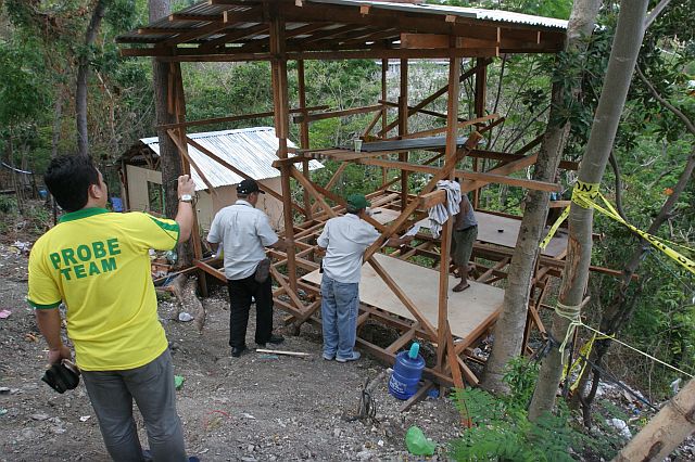 Members of the Prevention, Restoration, Order, Beautification and Enhancement (Probe) team advise carpenters to stop building houses while they distribute copies of a demolition order to illegal settlers at Osmeña Shrine in Barangay Kalunasan. (CDN PHOTO/JUNJIE MENDOZA)