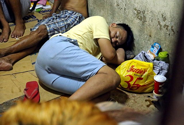 LOCKED UP. Benjie Dela Cerna, driver of the getaway motorcycle sleeps inside the Cebu City police holding cell. (CDN PHOTO/LITO TECSON)