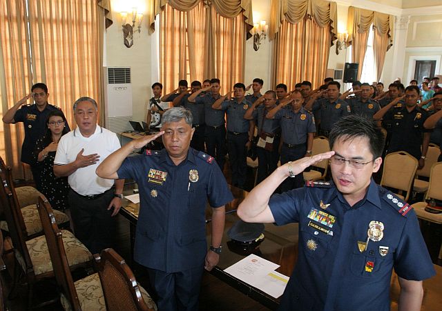 Cebu Gov. Hilario Davide III (center, front row), along  with Provincial Board Member Carmen Durano-Mica (2nd from left), PRO-7 director Chief Supt. Patrocinio Comendador Jr. (2nd from right), CPPO director Senior Supt. Clifford Gairanod and  PIB chief Supt. Rodolfo Albotra saluted the flag as the National Anthem is  played at the start of Capitol’s awarding of  cash incentives to PNP officials  involved in successful anti-drugs operations. (CDN PHOTO/JUNJIE MENDOZA)