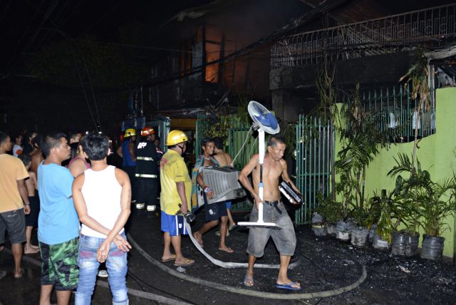 Fire victims try to carry whatever belongings they can bring out of what remained of their homes as firefighters put out the blaze that hit Lorega San Miguel. (CDN PHOTO/CHRISTIAN MANINGO)