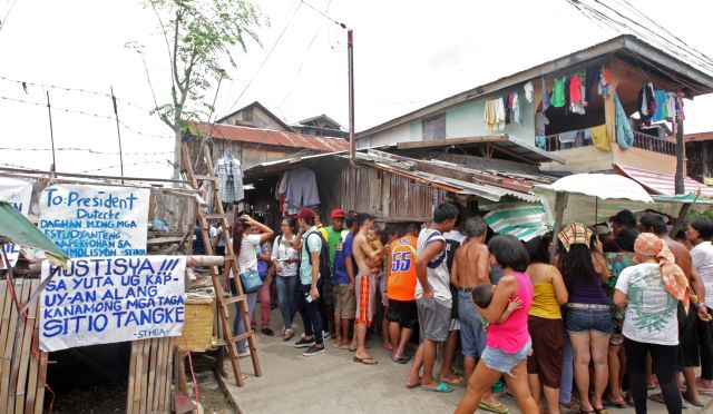 Worried settlers of a lot in Sitio Tangke, Alaska Barangay Mambaling discuss their fate after the scheduled demolition yesterday was moved to Wednesday because of bad weather. (CDN PHOTO/TONEE DESPOJO)