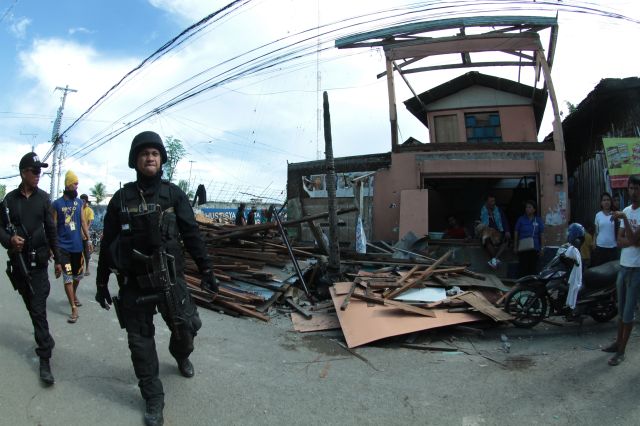 SWAT personnel secure the area where a demolition team took down nine houses in Sitio Tanke Alaska, Barangay Mambaling. (CDN PHOTO/ FERDINAND EDRALIN)