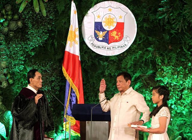 In this photo provided by the News and Information Bureau, Malacañang Palace, President Rodrigo Duterte is sworn in by Supreme Court Associate Justice Bienvenido Reyes in Malacañang. Holding the Bible is President Duterte’s daughter Veronica. Below right, Vice President Leni Robredo takes her oath of office. (AP PHOTO)