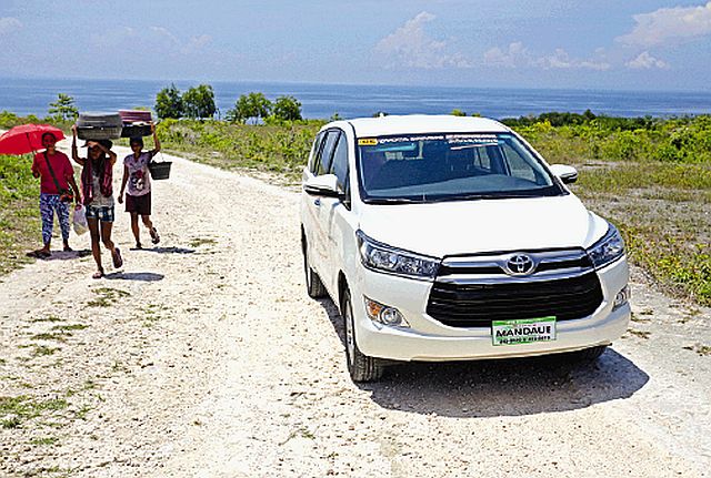 A group of locals pass by the all-new Toyota Innova in Borbon town, northern Cebu. (CDN PHOTO/LITO TECSON)