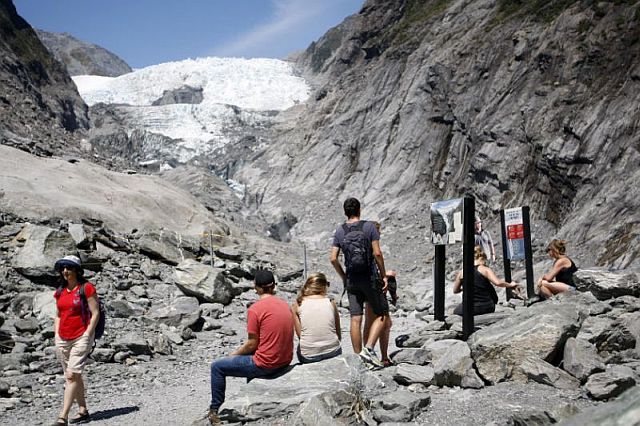   Tourists relax at the end of a track at the Franz Josef Glacier in New Zealand in this Feb. 6, 2016 photo. 