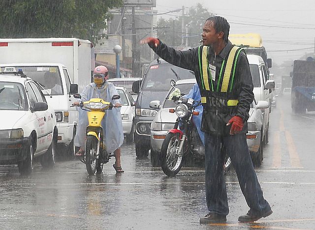 Regardless of the weather, traffic enforcers in Mandaue City, like this one detailed at Plaridel corner Ouano Street, still continue to perform their jobs. (CDN FILE PHOTO)