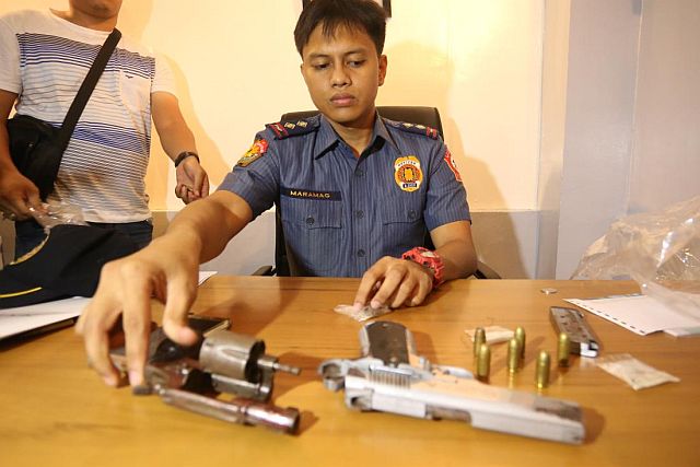 Senior Insp. Regino Maramag of Mambaling Police station presents the firearms used by the 2 drug suspects. (CDN PHOTO BY LITO TECSON)