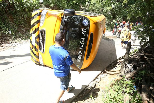 East Visayan Academy bus falls to its side after losing control in Pit-os, Talamban. (CDN PHOTO/LITO TECSON)
