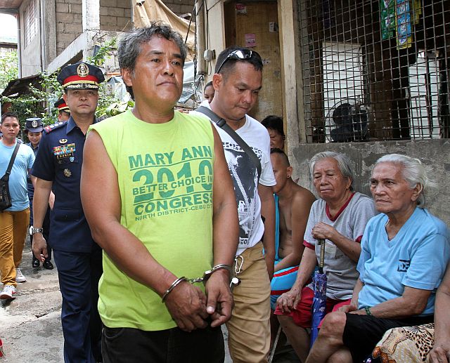  Newly appointed Cebu City Police Chief, Senior Supt. Joel Doria (in uniform) witnesses the arrest of suspected drug pusher Nestor Maghanoy (foreground) who had earlier surrendered to the police in line with Oplan Tokhang. He was caught repacking shabu inside his residence in  Barangay Mabolo. CDN PHOTO/JUNJIE MENDOZA