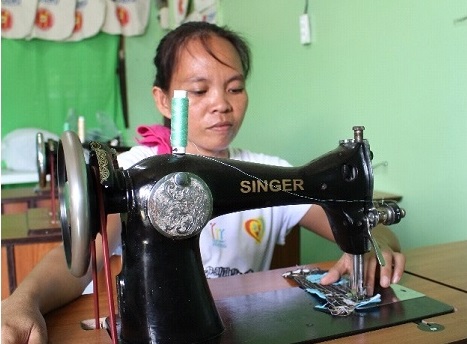 Jennifer Quiño tries out the group’s newly purchased sewing machine. (CONTRIBUTED PHOTO)