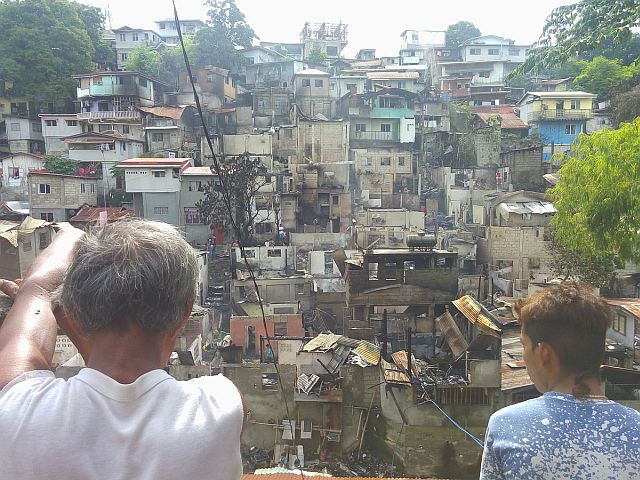 Some fire victims in Sitio Ponce, Barangay Capitol Site watch helplessly at their homes that was damaged by fire on Tuesday night. (CDN PHOTO/JUNJIE MENDOZA)