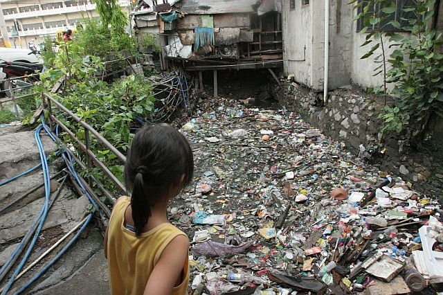 A child  looks into a creek in  A. Soriano St., Barangay Carreta, Cebu City that is filled with garbage after Friday’s massive flooding that occurred after hours of heavy rain. (CDN PHOTO/JUNJIE MENDOZA)