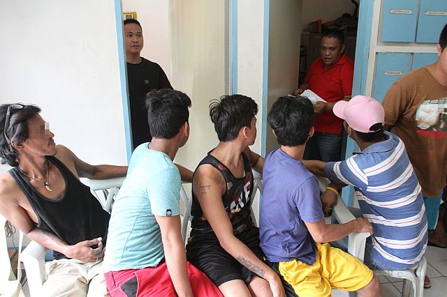 Some of the 70 self-confessed drug pushers and users (backs to camera) surrendered to the San Nicolas police. (CDN PHOTO/JUNJIE MENDOZA)