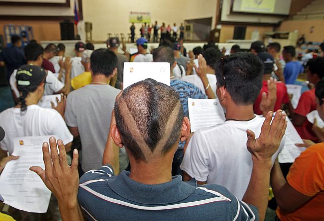 More than a hundred self-confessed drug personalities in Mandaue City take their oath of commitment to help end the drug menace before city and police officials yesterday at the Mandaue City Sports Complex. (CDN PHOTO/TONEE DESPOJO)
