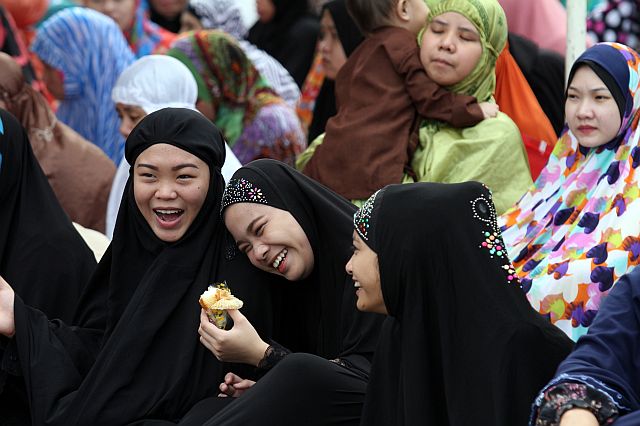 LAUGHTER. These young Muslim women break bread as they gathered in Plaza Independencia, Cebu City yesterday  to celebrate Eid al-Fitr, to mark the end of Ramadan. (CDN PHOTO/JUNJIE MENDOZA)