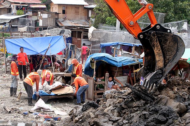 Personnel of the Department of Public Works and Highways (DPWH) assist settlers haul their belongings as they start dredging at the Mahiga creek on Logarta St., Mabolo, Cebu City. (CDN PHOTO/TONEE DESPOJO)