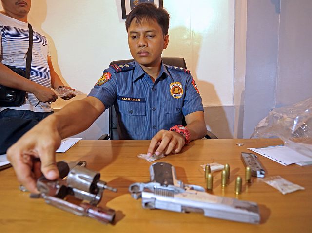 Senior Insp. Regino Maramag, Mambaling police chief, shows the guns and drugs seized from the suspects.  (CDN Photo/Lito Tecson)