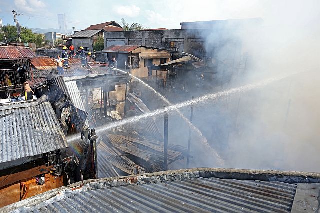 Firefighters battle the Barangay Tejero fire, which started at 7:58 a.m. and was put out 15 minutes later. (CDN PHOTO/LITO TECSON)