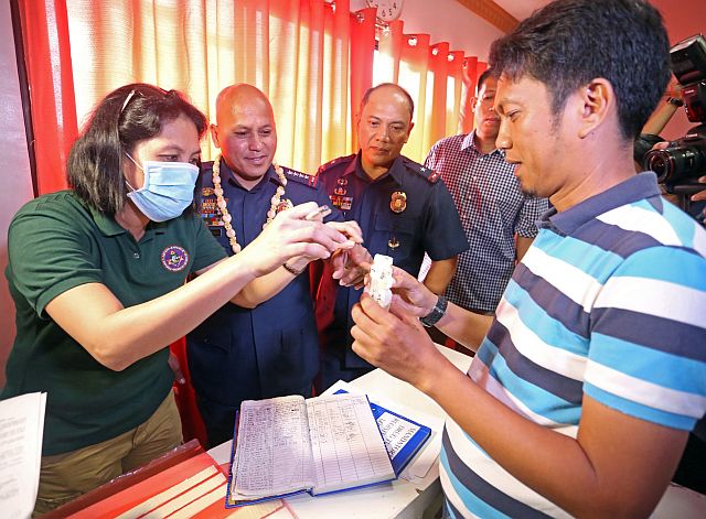 Arnold Bustamante (right), dyHP reporter and defense press corp president, submits his urine during a voluntary drug test at the Police Regional Office-7 headquarters. Police Director Gen. Ronald “Bato” Dela Rosa and PRO-7 Director, Chief Supt. Noli Talino (2nd and 3rd from left respectively) were present at the event. (CDN PHOTO/LITO TECSON)